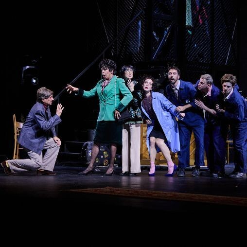 A scene showing a dramatic moment and a group listening in on it